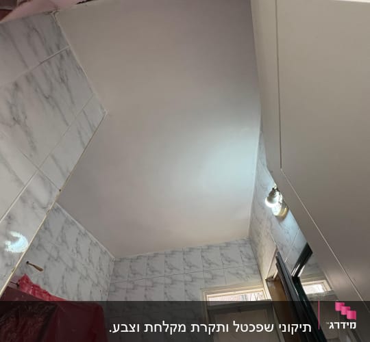 חדר אמבטיה עם תקרה צבועה וריצוף קרמיקה